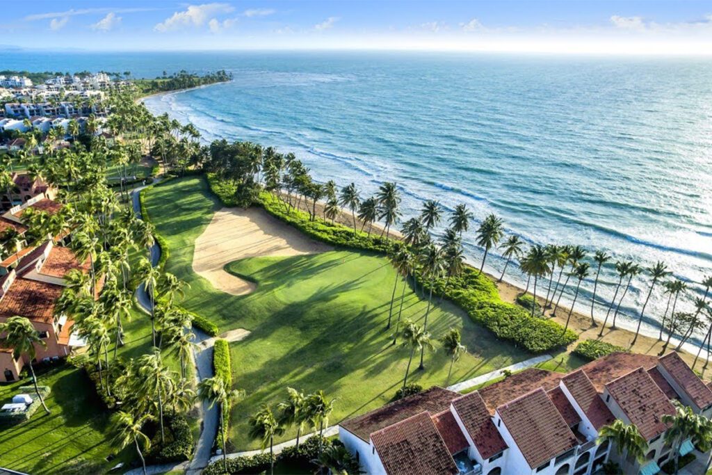It’s always been one of the best golf resorts in Puerto Rico. Now, the Wyndham Palmas resort has a bigger ambition: to be one of the island’s best resorts, period. The new-look Wyndham Palmas will be reopening its doors this May following a “dramatic” transformation, Caribbean Journal has learned. The Wyndham Palmas Beach and Golf Resort is set to complete its renovation and reopen on May 18, 2023. The multimillion-dollar renovation comes after the resort was acquired by LionGrove last year, and covers everything from the rooms to a significant new culinary concept. (LionGrove also owns the El San Juan resort property in Isla Verde.) So what’s changed? All of the hotel’s 107 rooms and suites got a new look, with new amenities and a “boho chic” aesthetic. The resort also transformed its lobby into a “modern and trendy” space, according to the company, with sweeping ceilings and larger windows. Other additions include new landscaping, a cigar lounge and upgraded event space. The hotel will also be debuting a new eatery called Trova Coastal Kitchen, the brainchild of Top Chef competitors and celebrity chefs Jeff McInnis and Janine Booth, in a concept helmed by Chef Julio Cartagena. "Chefs Jeff McInnis and Janine Booth are true culinary masters, and their numerous accolades and awards are a testament to their exceptional talent and dedication. We invite you to experience the world-renowned cuisine and impeccable service of Trova Coastal Kitchen, led by our own local chef Julio Cartagena," says Chris Sariego, Senior Managing Director and COO of LionGrove.  The hotel is set in the Palmas Del Mar community in Puerto Rico, anchored by a pair of world-class golf courses: one designed by Gary Player, the other by Rees Jones. For more, visit the Wyndham Palmas Puerto Rico.