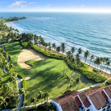 It’s always been one of the best golf resorts in Puerto Rico. Now, the Wyndham Palmas resort has a bigger ambition: to be one of the island’s best resorts, period. The new-look Wyndham Palmas will be reopening its doors this May following a “dramatic” transformation, Caribbean Journal has learned. The Wyndham Palmas Beach and Golf Resort is set to complete its renovation and reopen on May 18, 2023. The multimillion-dollar renovation comes after the resort was acquired by LionGrove last year, and covers everything from the rooms to a significant new culinary concept. (LionGrove also owns the El San Juan resort property in Isla Verde.) So what’s changed? All of the hotel’s 107 rooms and suites got a new look, with new amenities and a “boho chic” aesthetic. The resort also transformed its lobby into a “modern and trendy” space, according to the company, with sweeping ceilings and larger windows. Other additions include new landscaping, a cigar lounge and upgraded event space. The hotel will also be debuting a new eatery called Trova Coastal Kitchen, the brainchild of Top Chef competitors and celebrity chefs Jeff McInnis and Janine Booth, in a concept helmed by Chef Julio Cartagena. "Chefs Jeff McInnis and Janine Booth are true culinary masters, and their numerous accolades and awards are a testament to their exceptional talent and dedication. We invite you to experience the world-renowned cuisine and impeccable service of Trova Coastal Kitchen, led by our own local chef Julio Cartagena," says Chris Sariego, Senior Managing Director and COO of LionGrove.  The hotel is set in the Palmas Del Mar community in Puerto Rico, anchored by a pair of world-class golf courses: one designed by Gary Player, the other by Rees Jones. For more, visit the Wyndham Palmas Puerto Rico.