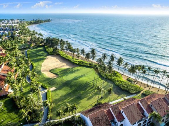 It’s always been one of the best golf resorts in Puerto Rico. Now, the Wyndham Palmas resort has a bigger ambition: to be one of the island’s best resorts, period. The new-look Wyndham Palmas will be reopening its doors this May following a “dramatic” transformation, Caribbean Journal has learned. The Wyndham Palmas Beach and Golf Resort is set to complete its renovation and reopen on May 18, 2023. The multimillion-dollar renovation comes after the resort was acquired by LionGrove last year, and covers everything from the rooms to a significant new culinary concept. (LionGrove also owns the El San Juan resort property in Isla Verde.) So what’s changed? All of the hotel’s 107 rooms and suites got a new look, with new amenities and a “boho chic” aesthetic. The resort also transformed its lobby into a “modern and trendy” space, according to the company, with sweeping ceilings and larger windows. Other additions include new landscaping, a cigar lounge and upgraded event space. The hotel will also be debuting a new eatery called Trova Coastal Kitchen, the brainchild of Top Chef competitors and celebrity chefs Jeff McInnis and Janine Booth, in a concept helmed by Chef Julio Cartagena. "Chefs Jeff McInnis and Janine Booth are true culinary masters, and their numerous accolades and awards are a testament to their exceptional talent and dedication. We invite you to experience the world-renowned cuisine and impeccable service of Trova Coastal Kitchen, led by our own local chef Julio Cartagena," says Chris Sariego, Senior Managing Director and COO of LionGrove.  The hotel is set in the Palmas Del Mar community in Puerto Rico, anchored by a pair of world-class golf courses: one designed by Gary Player, the other by Rees Jones. For more, visit the Wyndham Palmas Puerto Rico.