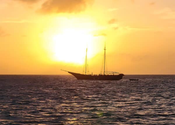 aruba setting sun yellow with boat in background