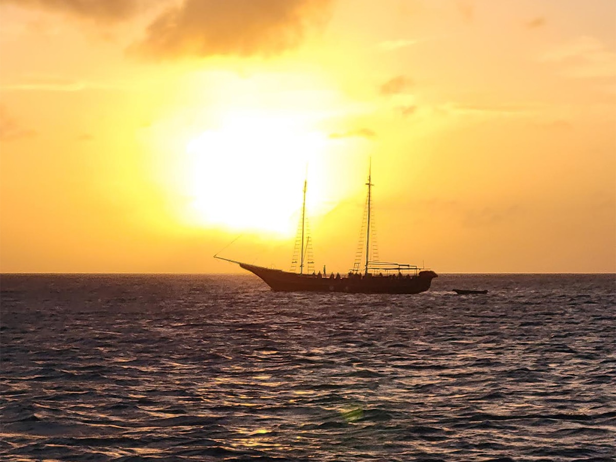 aruba setting sun yellow with boat in background
