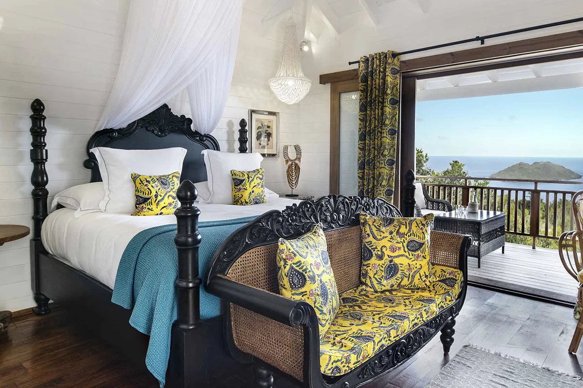 inside a room with four-poster bed and ocean view