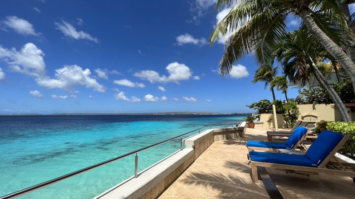 blue water next to chairs and a balcony