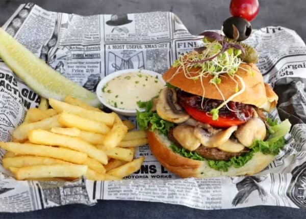 aruba comfort food with hamburgers and fries on a newspaper