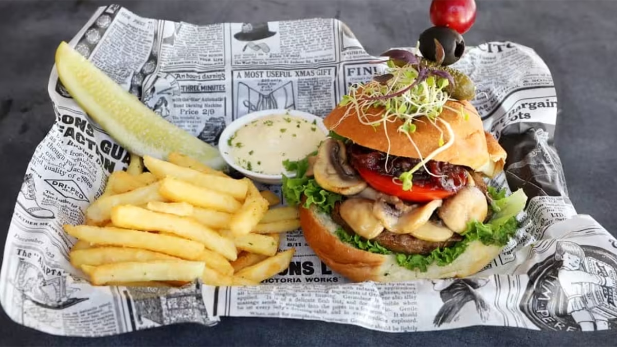 aruba comfort food with hamburgers and fries on a newspaper
