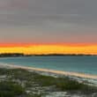 beach on great harbour cay at sunset with blue water