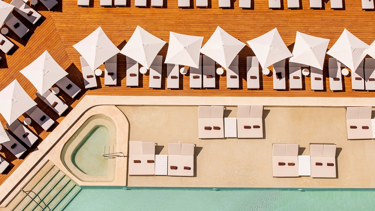 aerial photo of pool and lounge chairs with hot tub