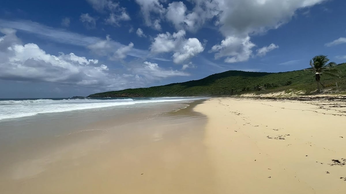 playa resaca culebra beach with green hills and clouds in blue sky