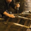 man opening barrel with rum