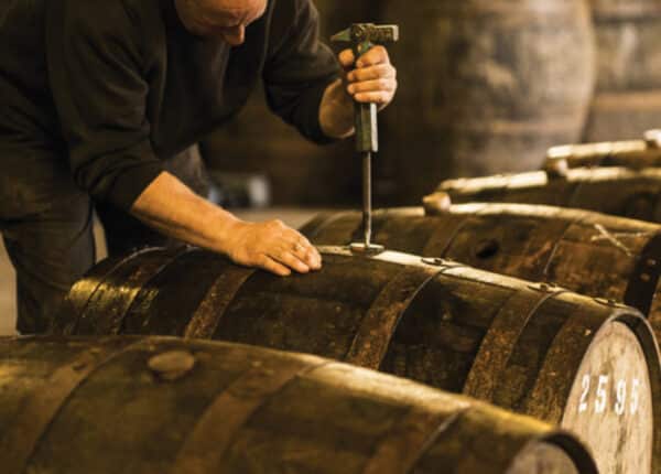 man opening barrel with rum