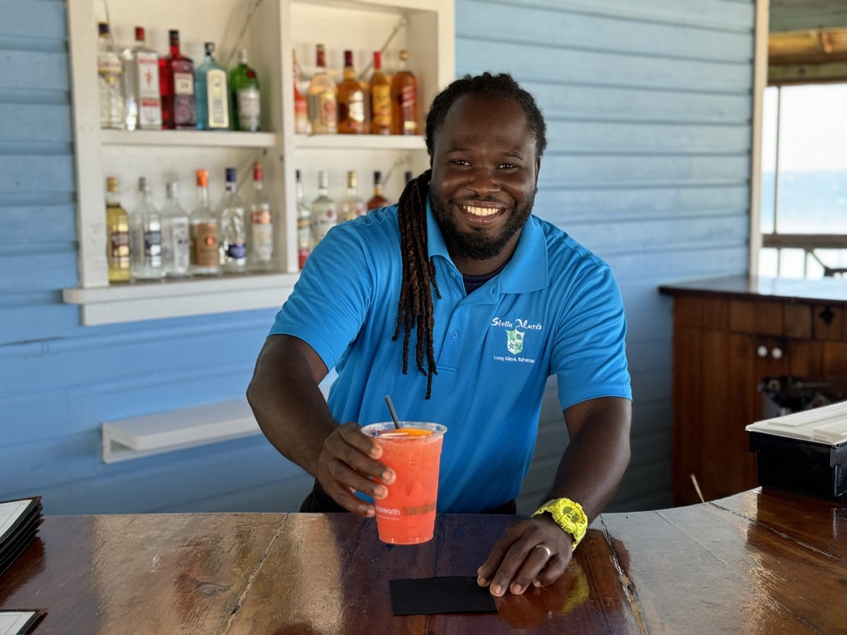 gerald with a rum punch and bar behind him
