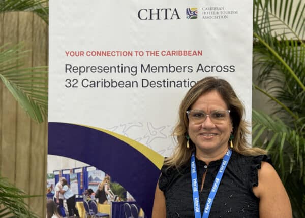 barbados hotelier in front of chta sign