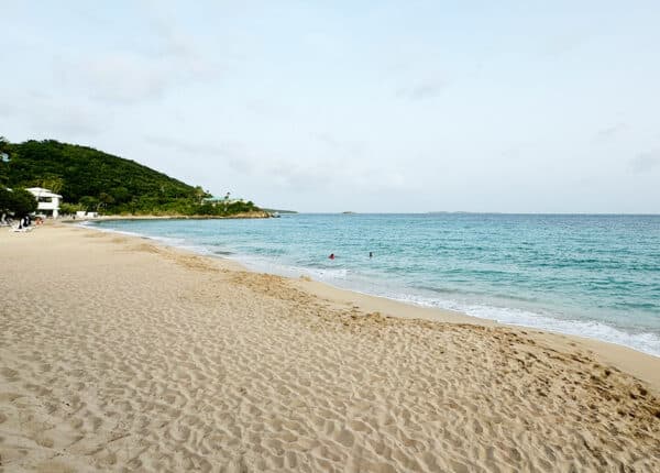 beach at buoy haus hotel in st thomas with green hills