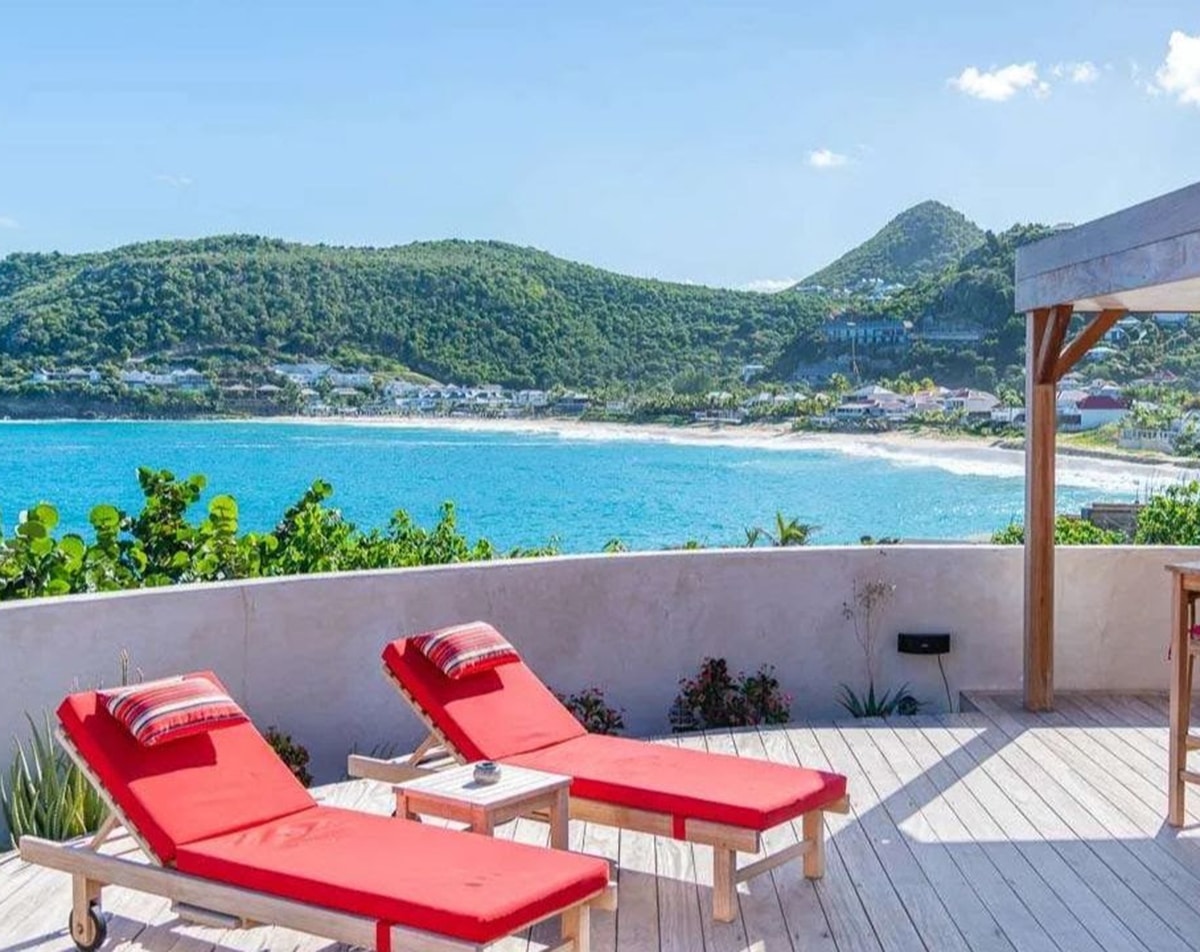 caribbean island st barth red chairs with hills in background